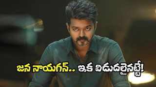 A man with an intense look sitting at a table in a dramatic film still, symbolizing tension and conflict.