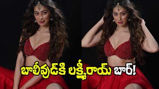 A woman in a glamorous red costume poses confidently against a black background, styled with traditional jewelry and bold makeup.