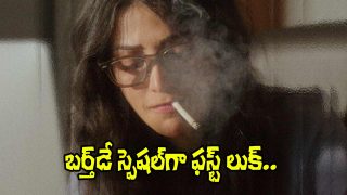 A woman wearing glasses is seen through a misty surface, holding a cigarette, with smoke partially obscuring her face.